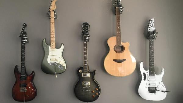 Guitars hanging on the wall. Gibson Les Paul, Fender Stratocaster.