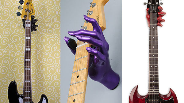 Three guitar hangers on the wall holding a Fender bass and Epiphone guitars. Gift Ideas for guitar lovers.