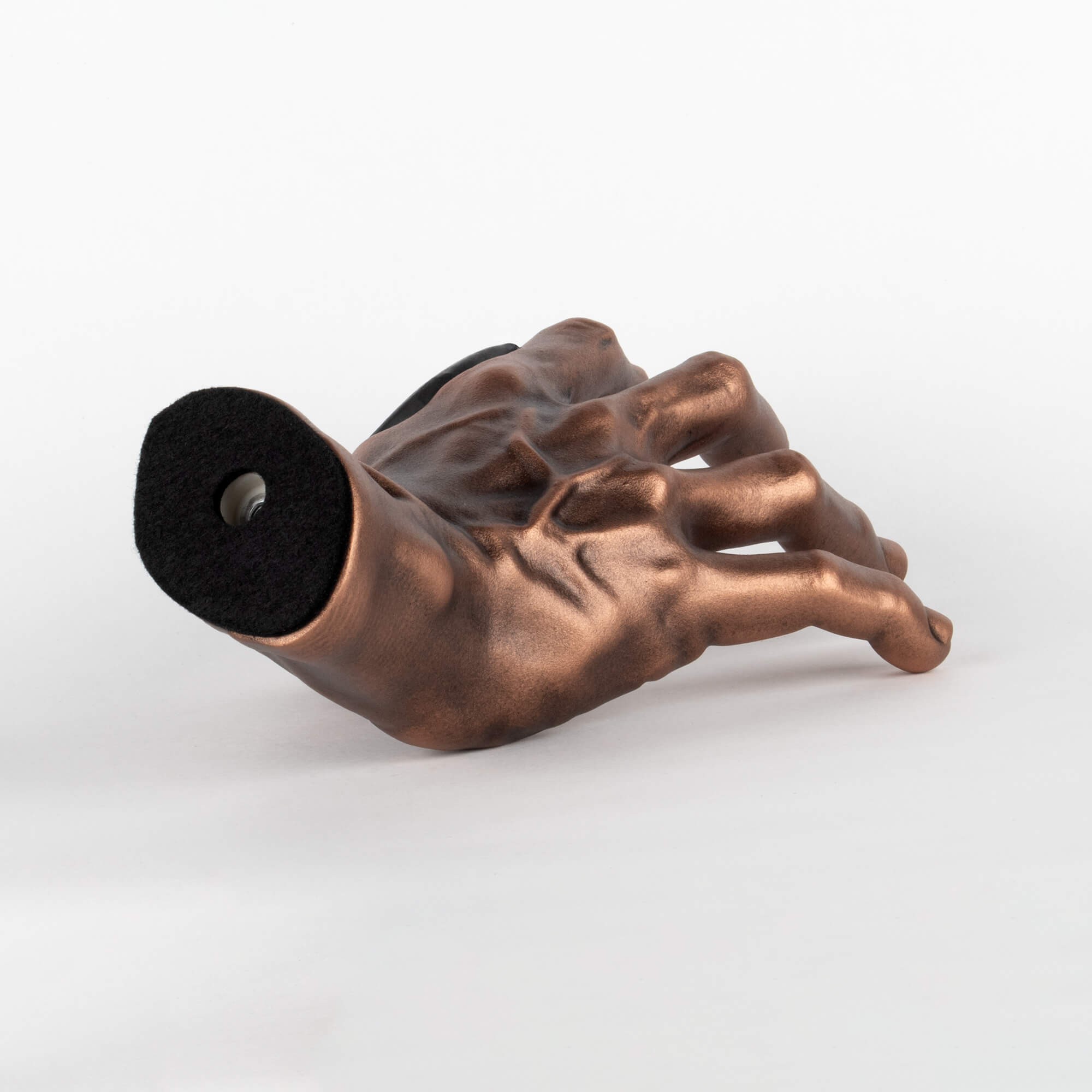 Wall mount for a guitar that is shaped like a copper antiqued hand.