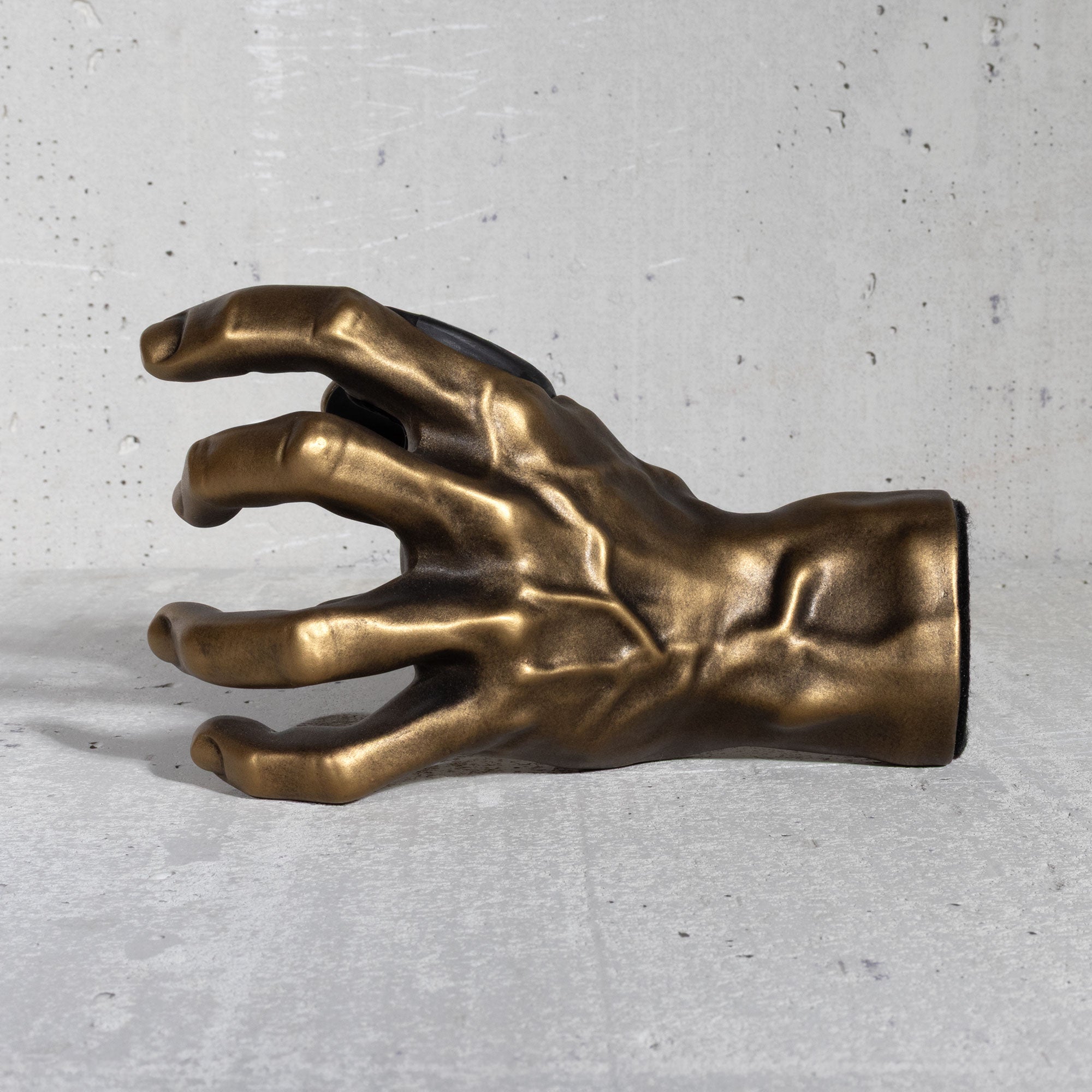 Gold hand sculpture guitar hanger on a gray background
