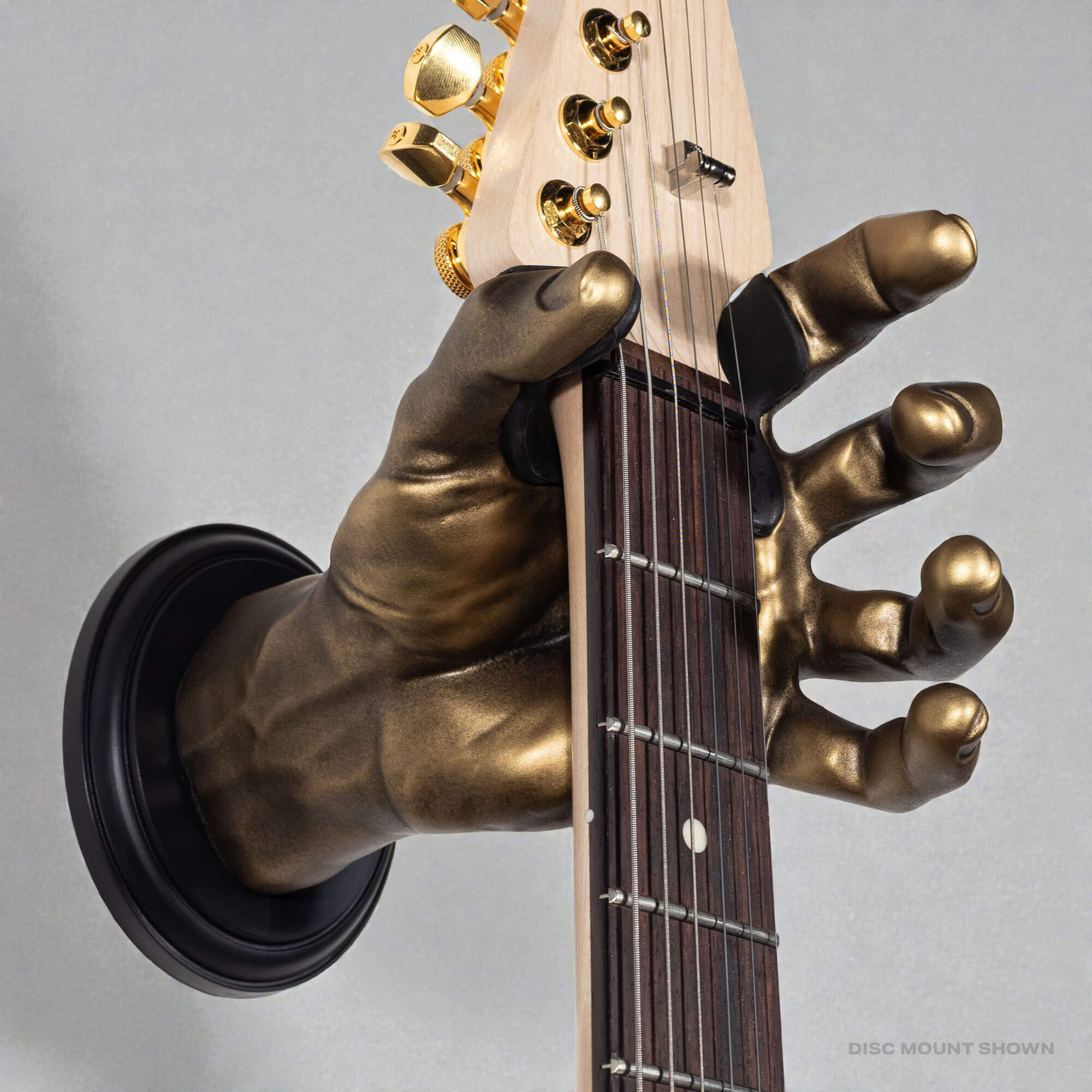 Hand shaped guitar hanger from GuitarGrip holding stratocaster.