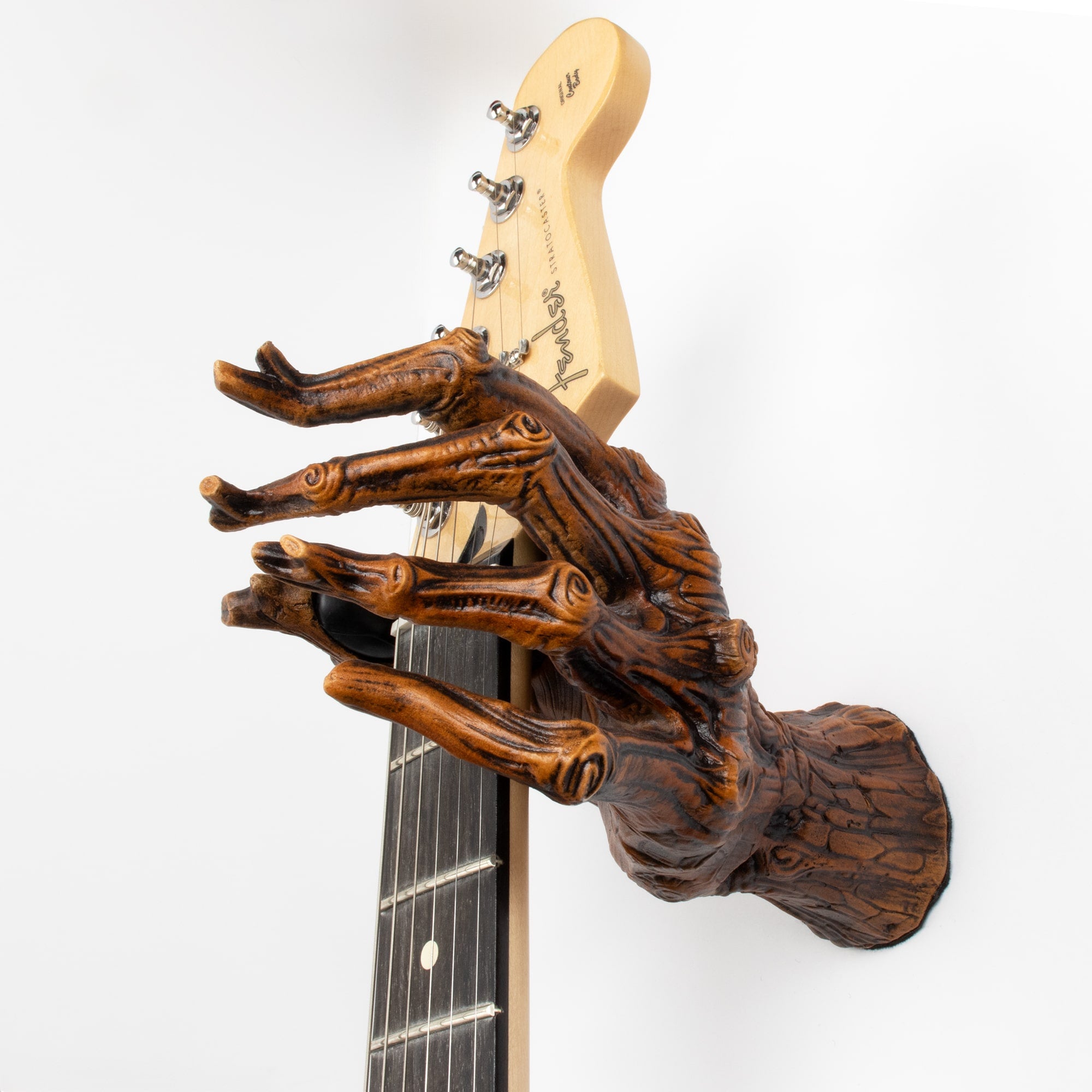Tree branch guitar hanger wall hook mount holding stratocaster guitar.