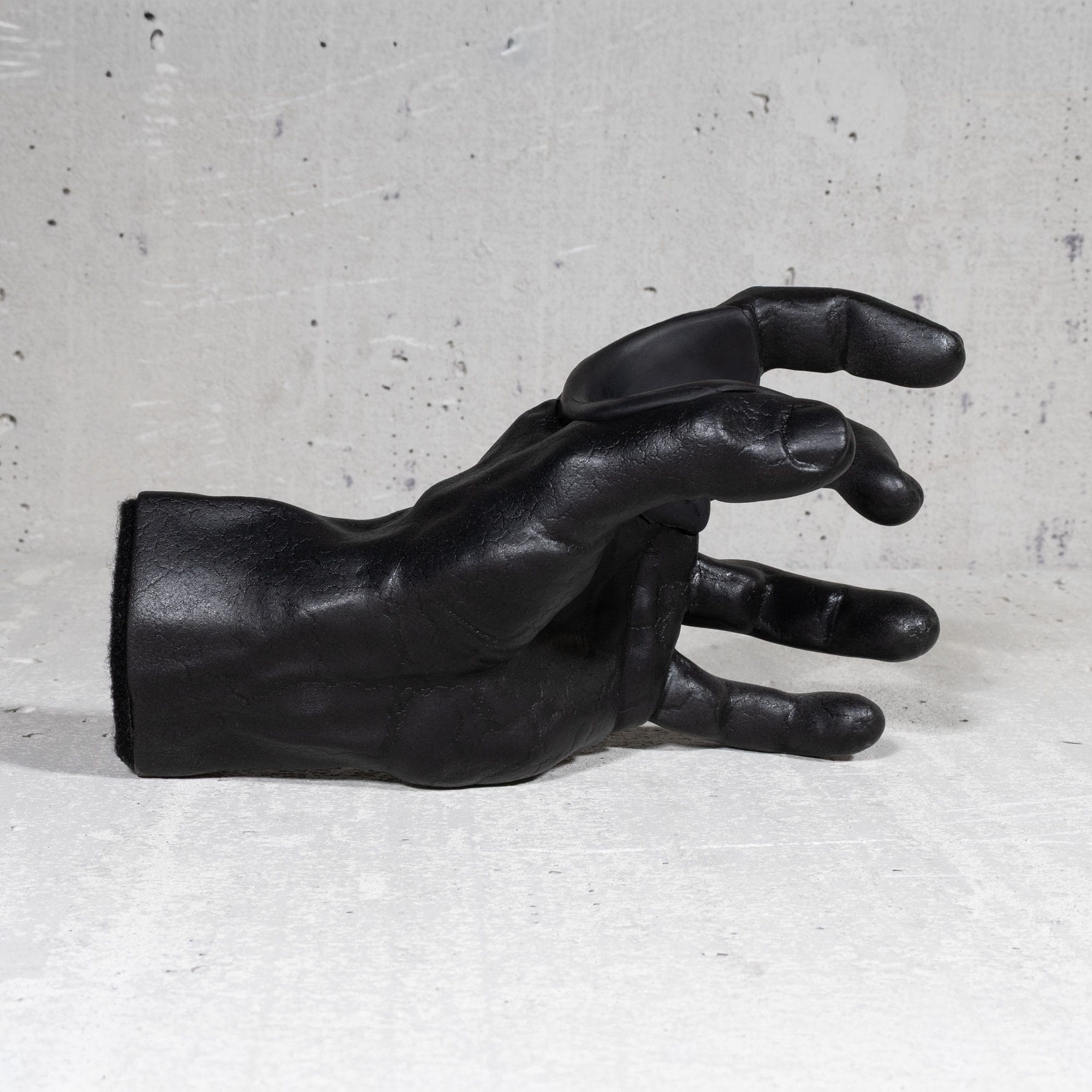 Black crackle finish hand shaped guitar hanger on grey background.