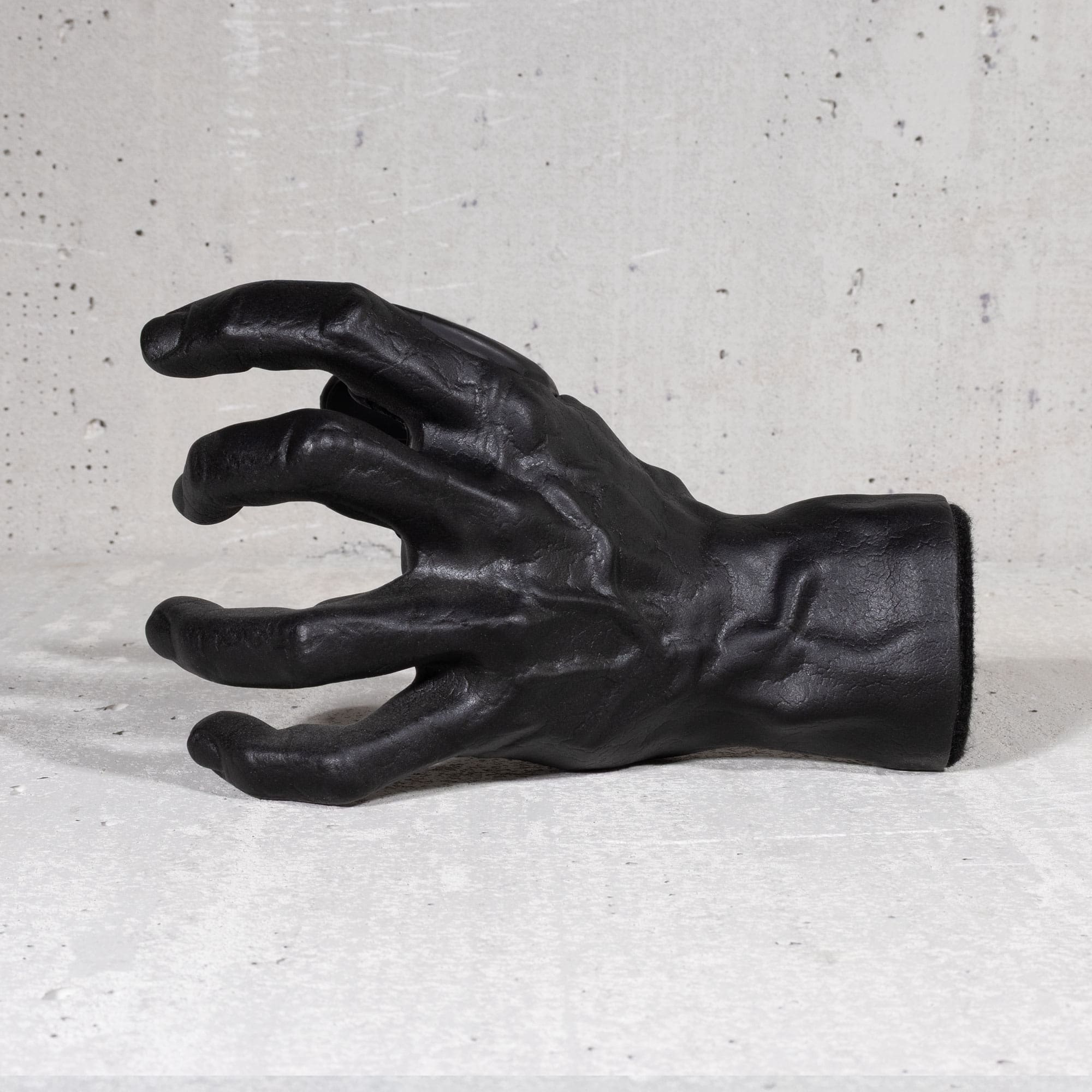 Black hand guitar hook wall mount on grey background.