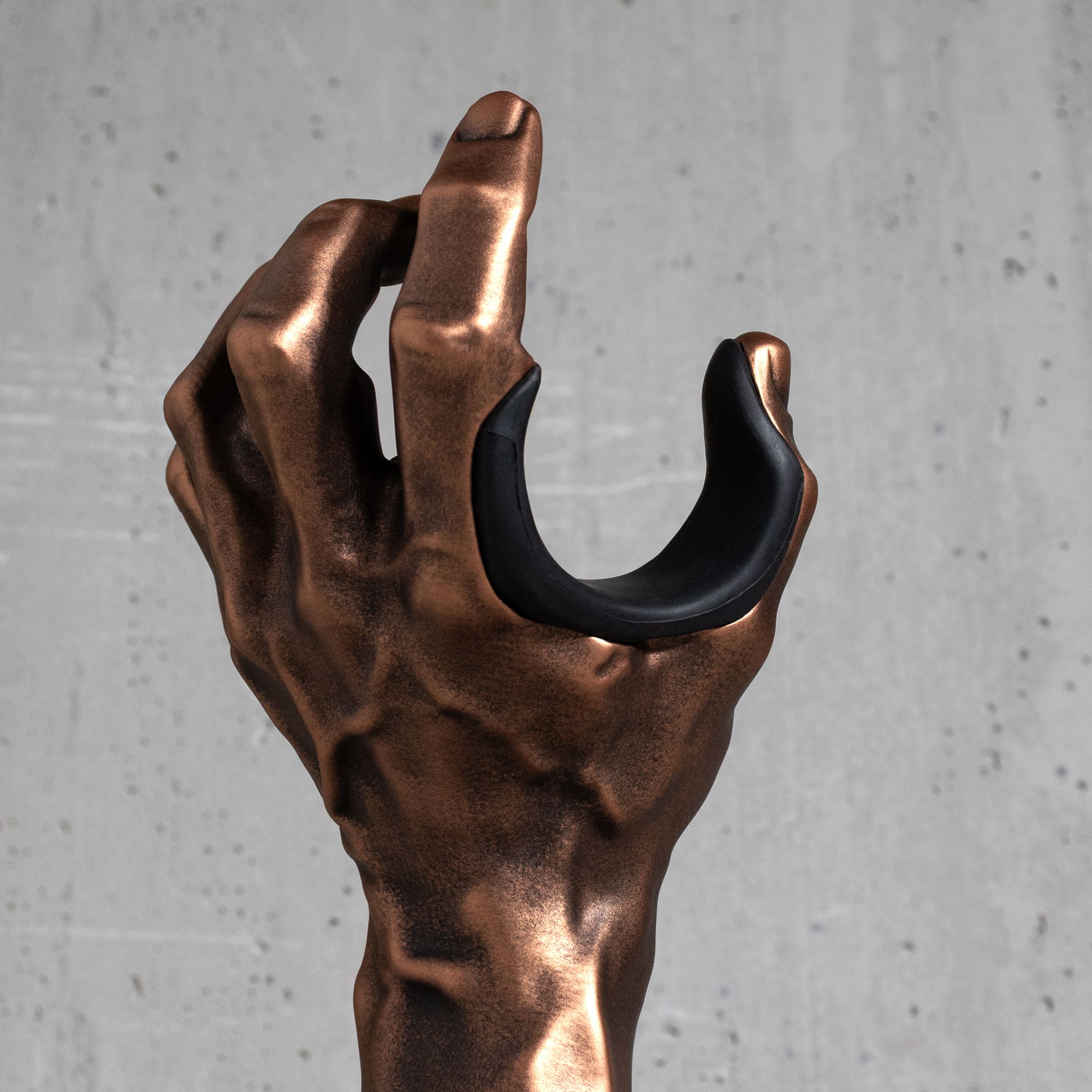 Close-up of the Copper GuitarGrip left-hand guitar hanger showing the cushioned finger pad.