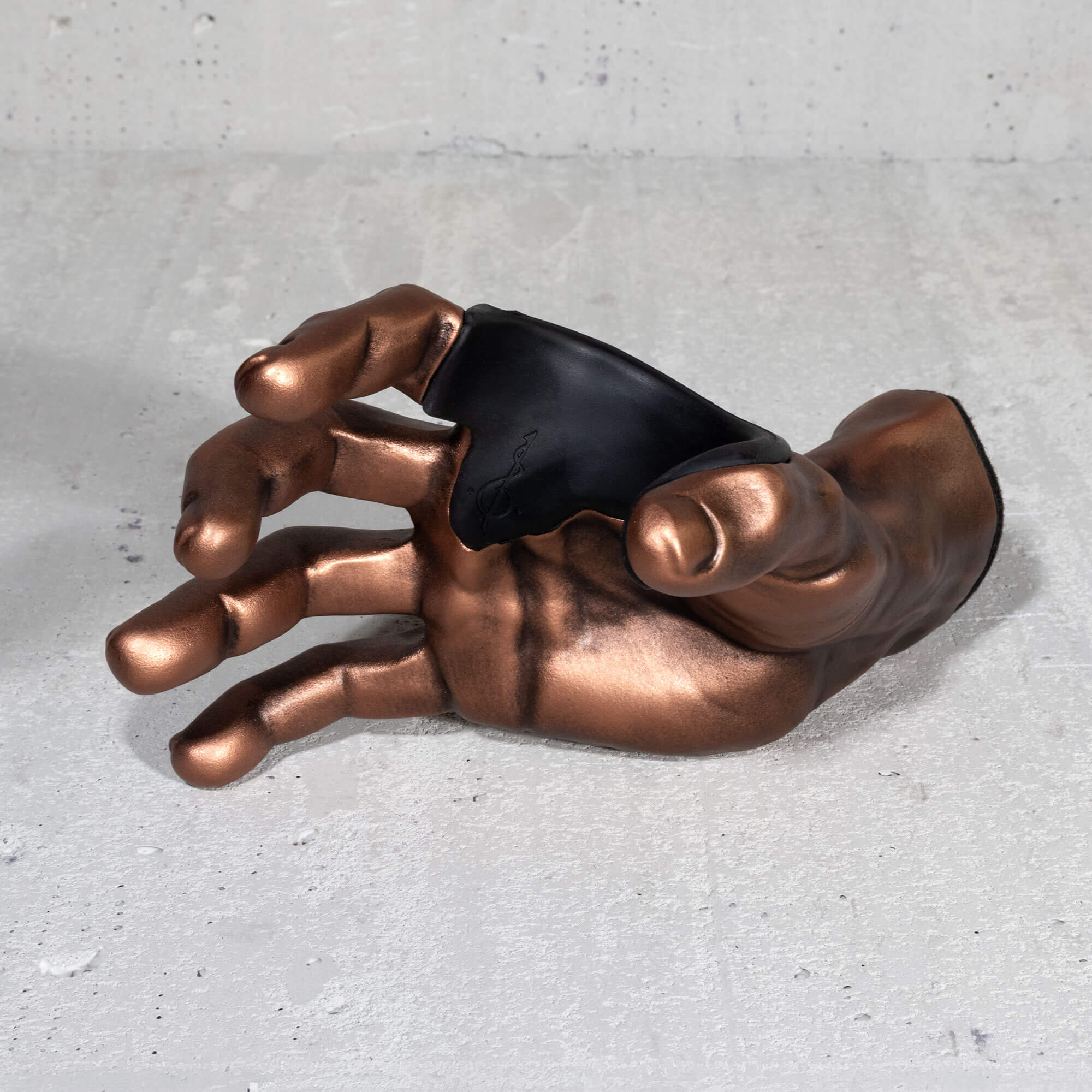 Copper hand guitar hanger wall hook frontview on grey background.