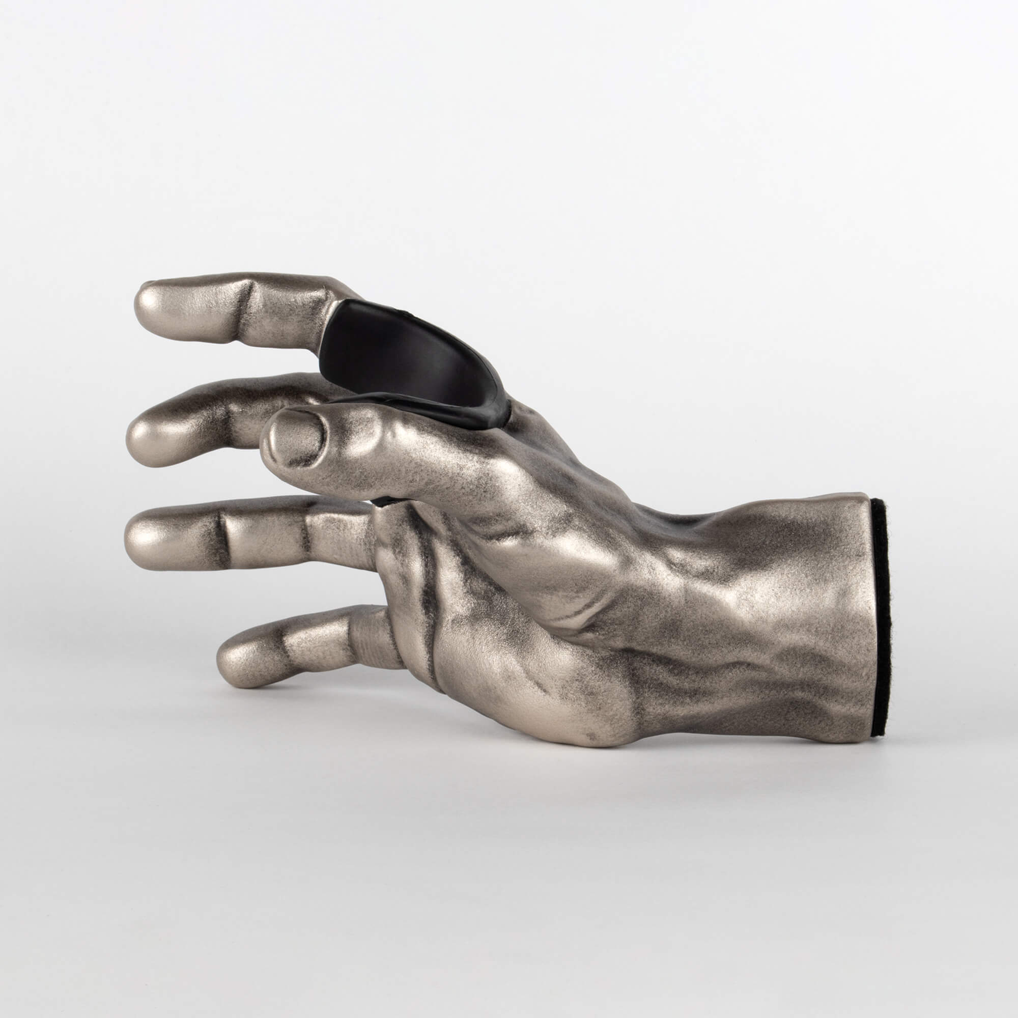 Inside view of antiqued silver hand used to mount instruments, specifically guitars, to the wall.