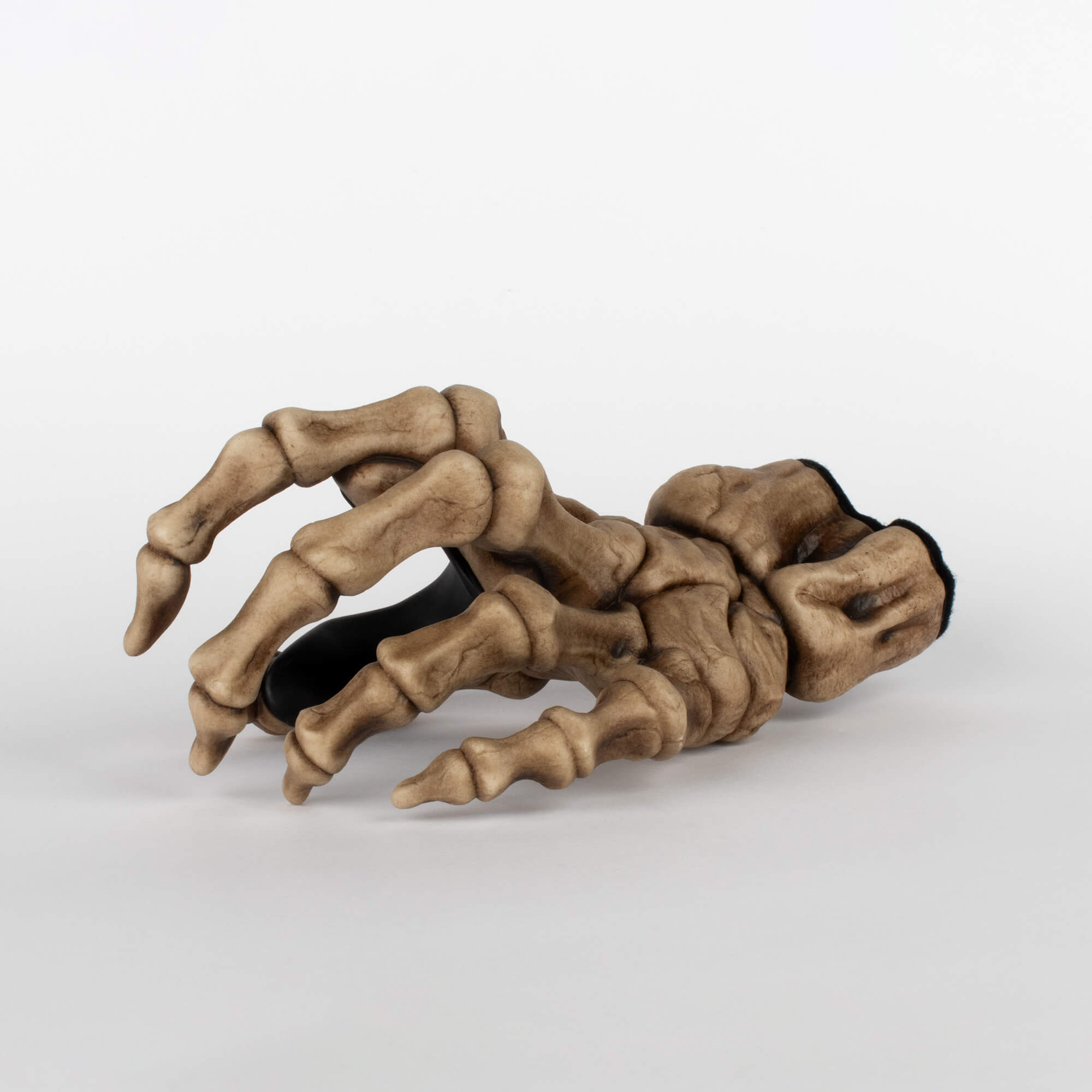 GuitarGrip beige bone skeleton wall hanger for hanging electric and acoustic guitars, angled front view on white background.