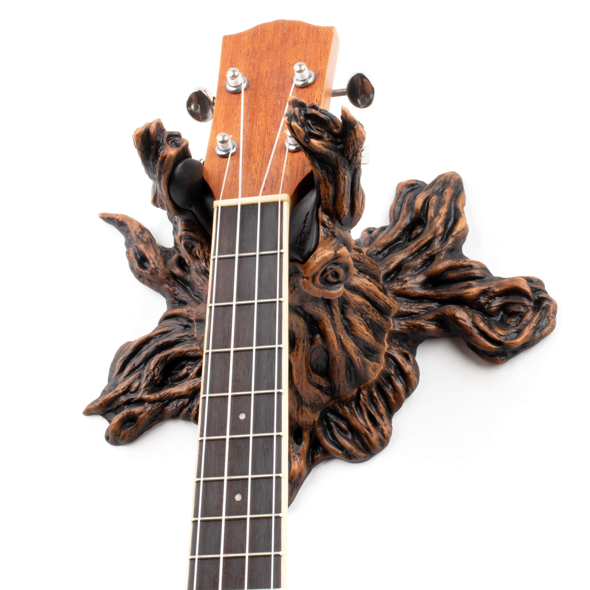 Tree branch wall hanger for acoustic guitar and ukulele on white background.