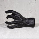 Black hand guitar hook wall mount on grey background.