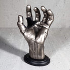 Silver antiqued hand guitar hanger upright view on grey background.