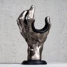 Silver hand guitar hanger wall mount on grey wall.