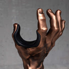 Guitargrip hand shaped guitar hanger in copper color on grey background.