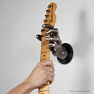 GuitarGrip silver male hand holding a telecaster guitar on the wall. 