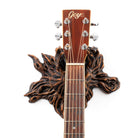 Acoustic guitar hanger that looks like a tree branch on white wall.